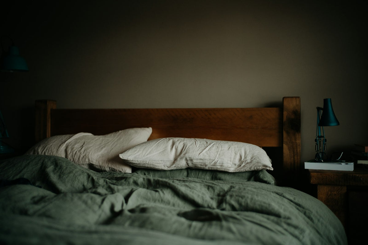 Bed with sage green comforter and pillows
